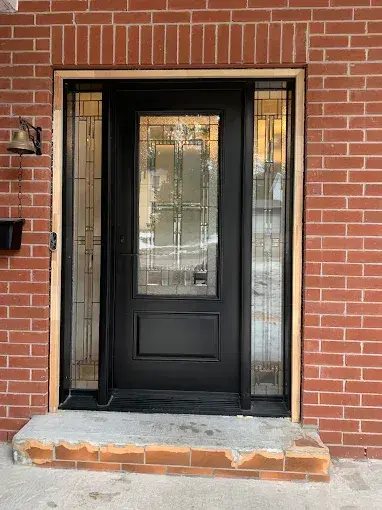 Black front entry door with decorative glass sidelights